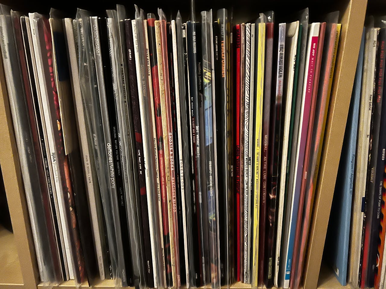 Close-up of diverse vinyl records neatly stacked on a shelf.